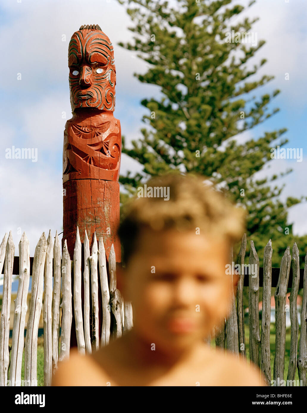 Un ragazzo Maori e una figura scolpita a scuola ingresso, Torere, costa Nord, Eastcape, Isola del nord, Nuova Zelanda Foto Stock