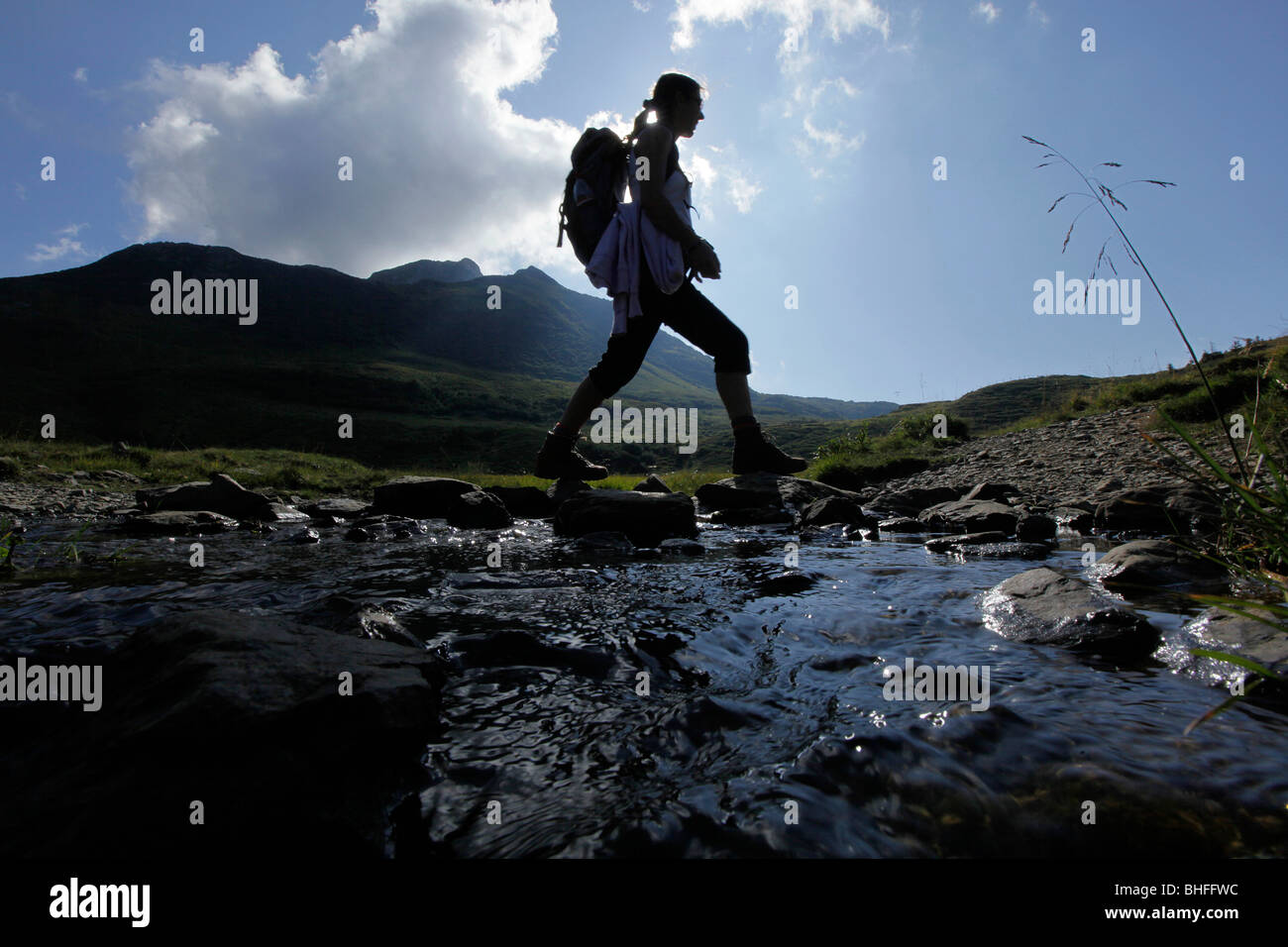 Escursionista femmina il passaggio di flusso, le Alpi Carniche, Carinzia, Austria Foto Stock