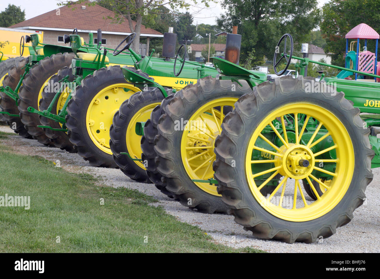 John Deere per i trattori agricoli con colore giallo brillante ruote tutti in riga Foto Stock