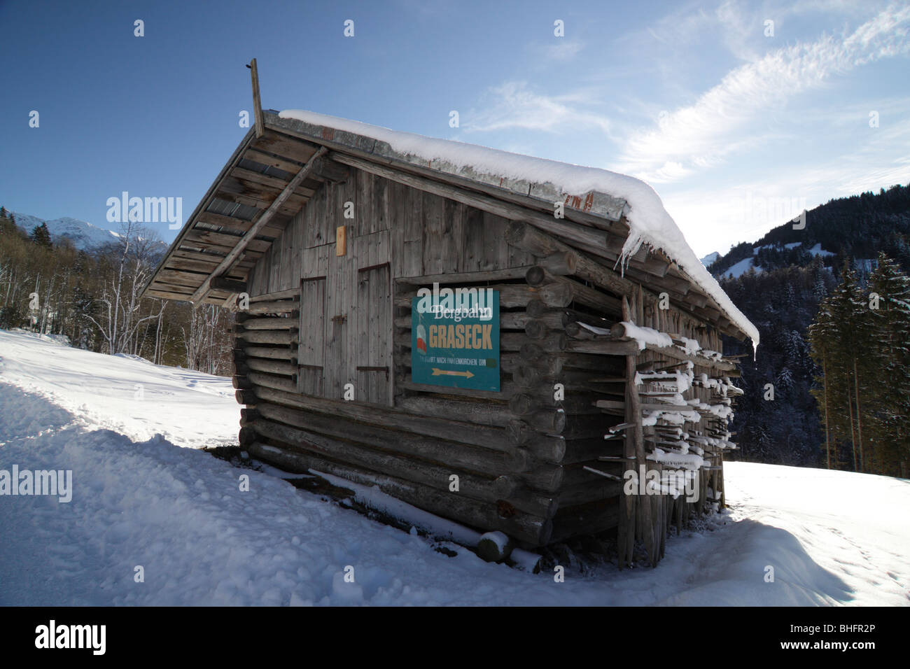 Una capanna nelle Alpi con un segno per il Graseck funivia su una chiara e luminosa giornata invernale con un sacco di neve. Foto Stock