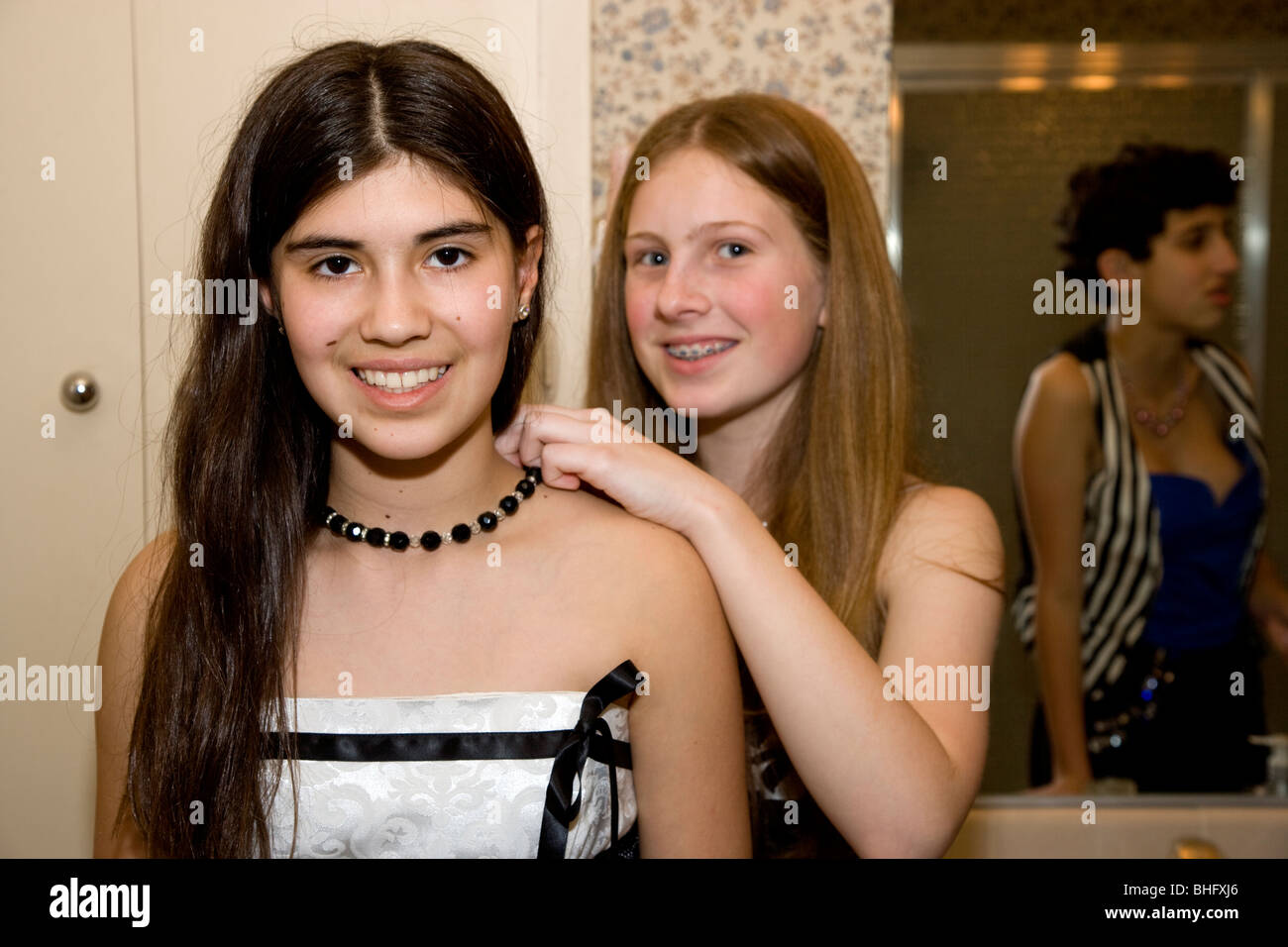 Preparazione per il loro ballo formale, cinque multi-etnico ragazze mettendo su make up e fare i loro capelli nel bagno. Foto Stock
