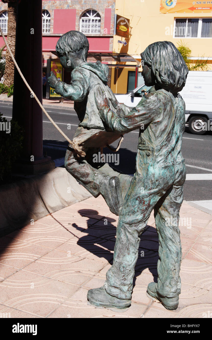 Scultura in bronzo in Spagna di bambini che giocano su swing Foto Stock