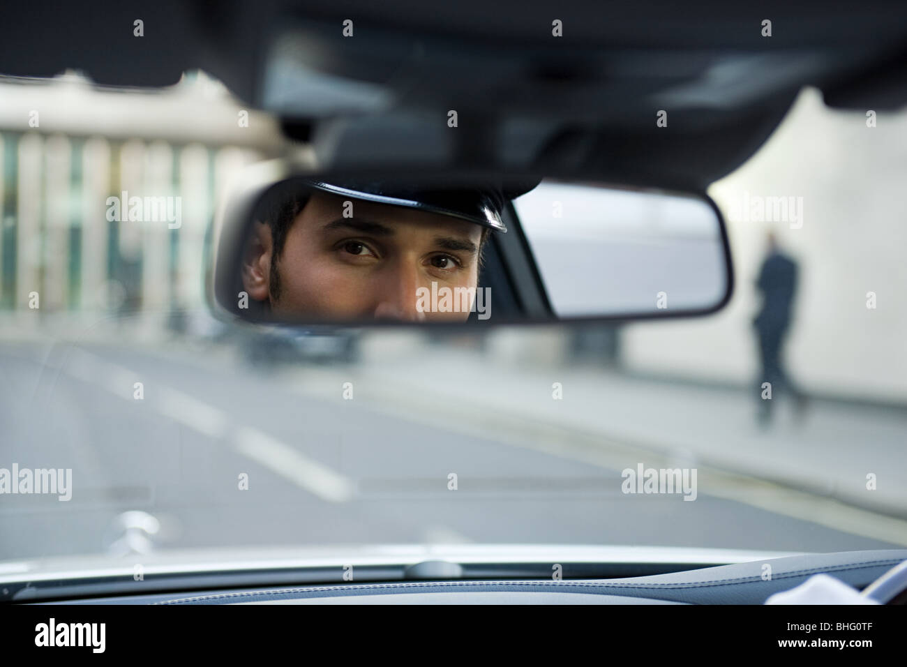 Chauffeur cercando in specchio retrovisore Foto Stock
