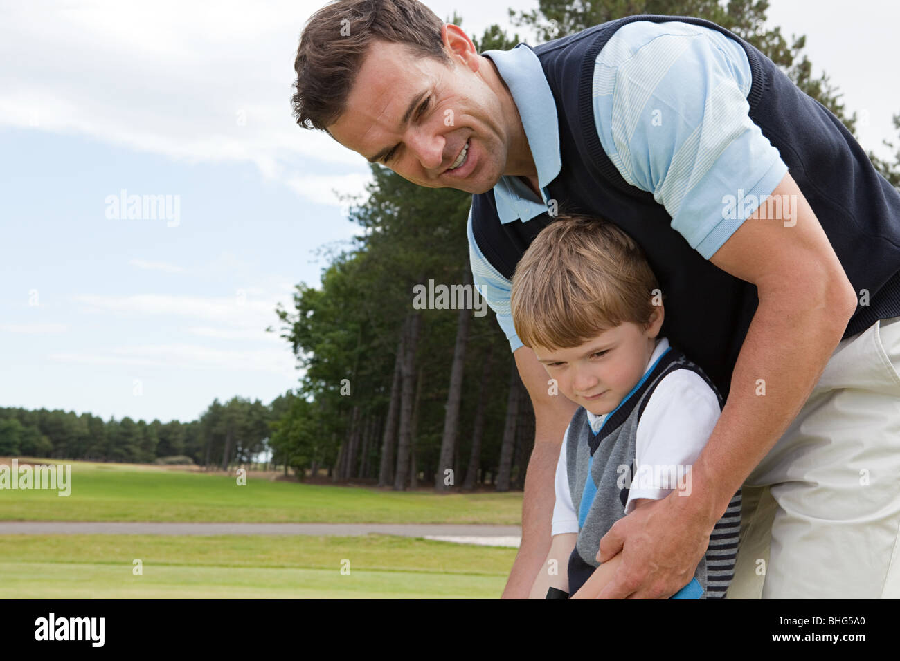 Padre insegnando il suo figlio golf Foto Stock