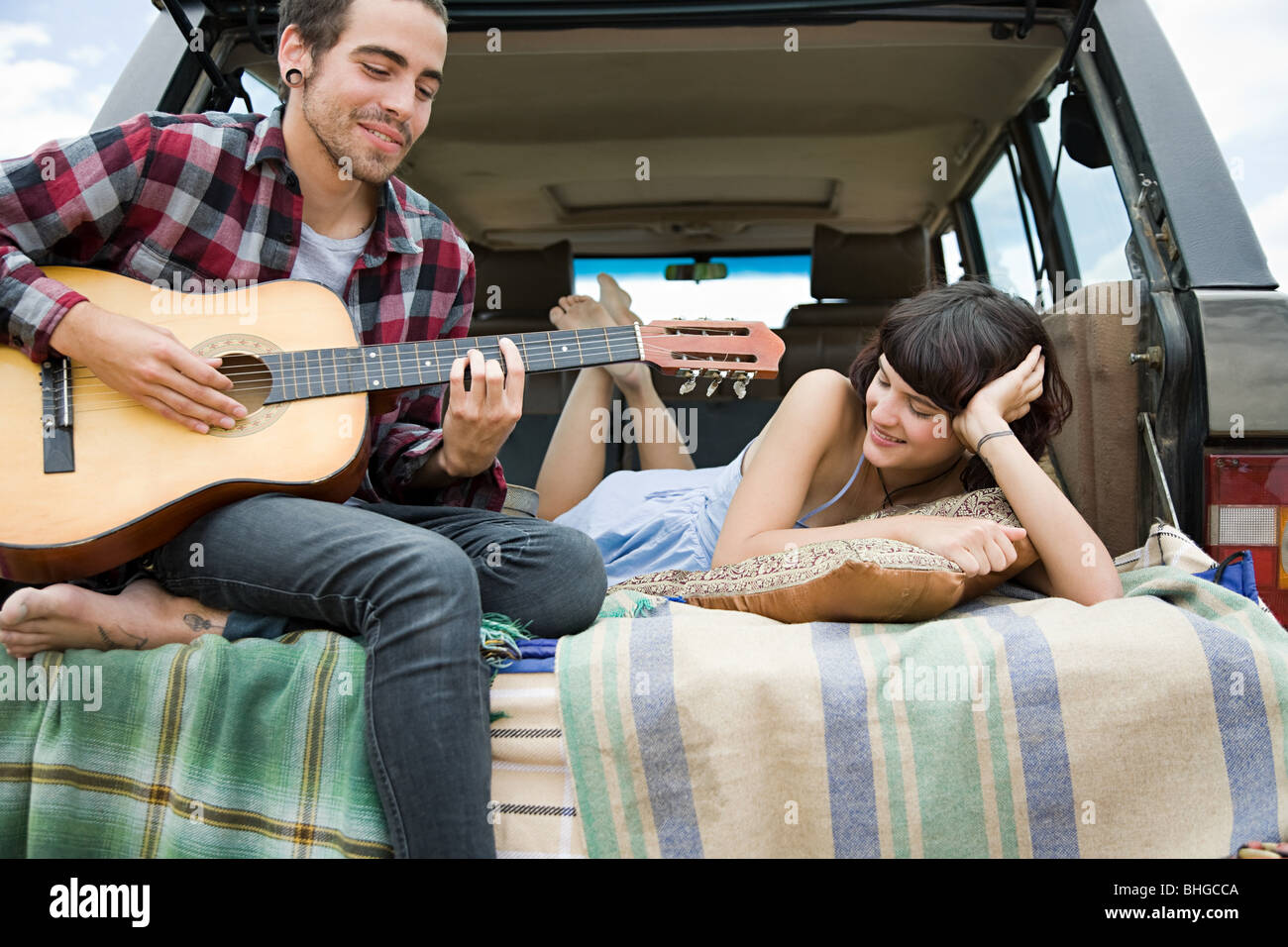 Giovane uomo a suonare la chitarra per ragazza Foto Stock