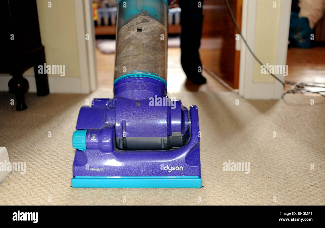 Donna che utilizza un dyson aspirapolvere per pulire i tappeti in casa Foto  stock - Alamy