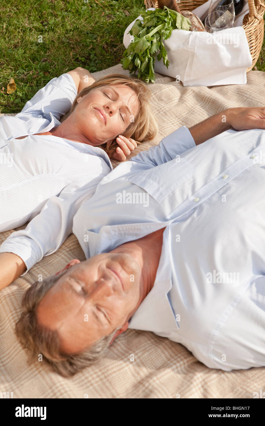 Coppia di mezza età su una coperta picnic Foto Stock