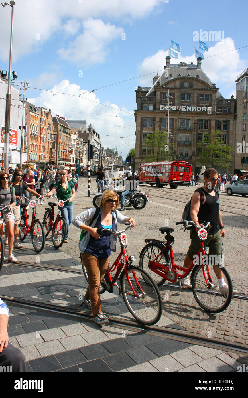 I turisti con affittato delle biciclette in Piazza Dam, Amsterdam, Paesi Bassi Foto Stock