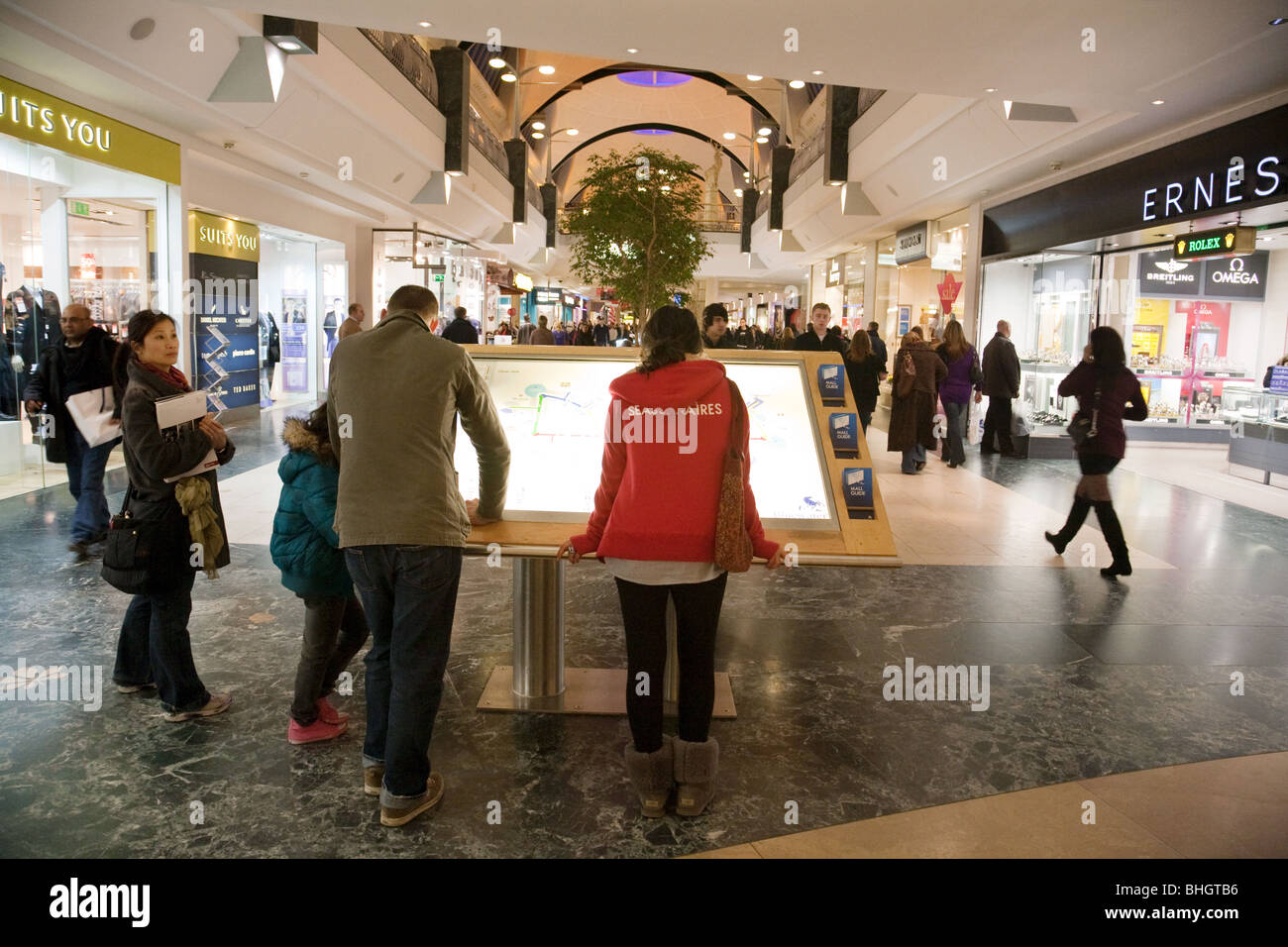Shoppers osservando il negozio Registrati Mappa del Centro commerciale Bluewater Shopping Centre, Kent, Regno Unito Foto Stock