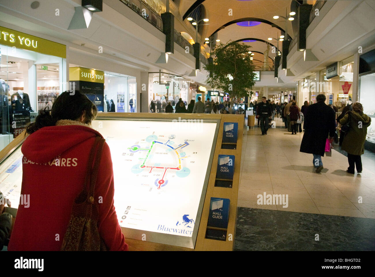 Shoppers guardando la mappa del centro commerciale Bluewater Shopping Centre, Kent, Regno Unito Foto Stock