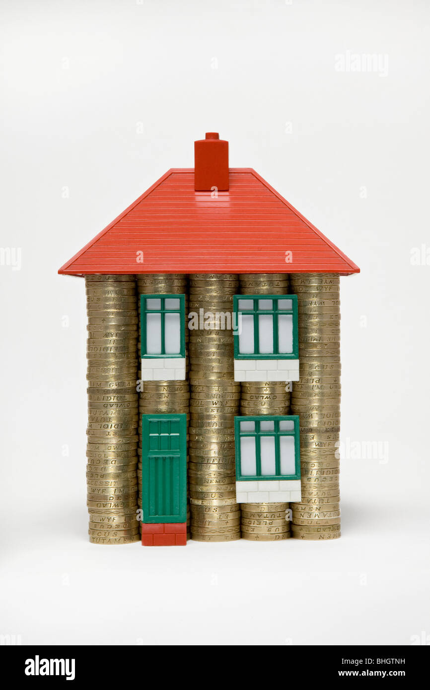Una casa fatta di pile di monete da sterline e parti di un giocattolo Bayko anni '60 - foto utilizza vecchie monete da £1 che sono state tolte dalla circolazione nell'ottobre 2017 Foto Stock