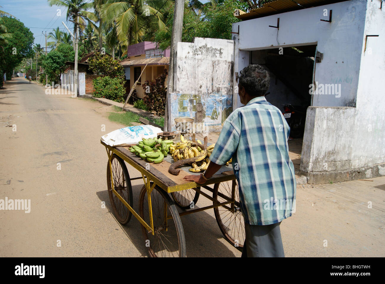 Banana per la vendita. Un povero uomo vendita vagare lungo il vasto e lungo le strade indiane tirando le sue ruote per la vendita di banane. Foto Stock