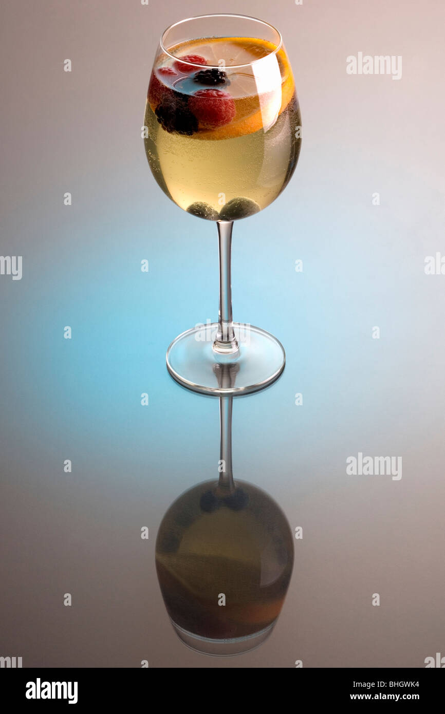 Bicchiere di vino bianco sangria su uno sfondo grigio con la riflessione Foto Stock
