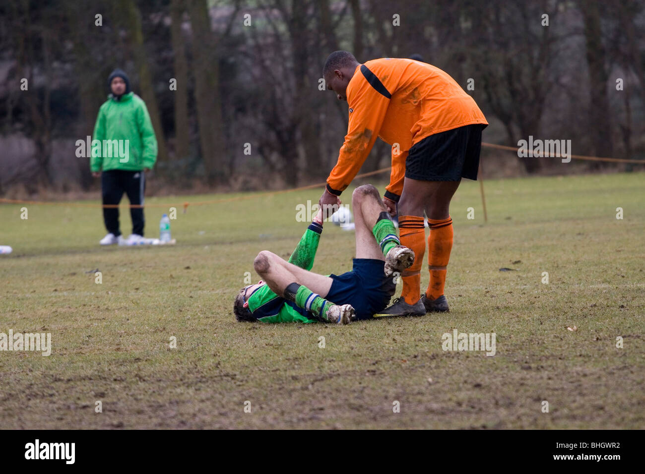 Un giocatore della squadra avversaria ad aiutare un ferito avversario mostrando il fair play e sportività Foto Stock