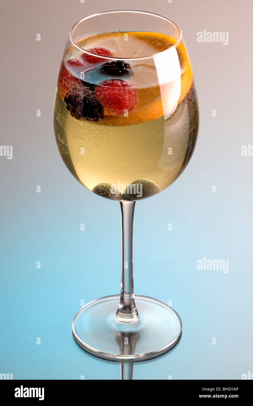 Bicchiere di vino bianco sangria su uno sfondo grigio con la riflessione Foto Stock