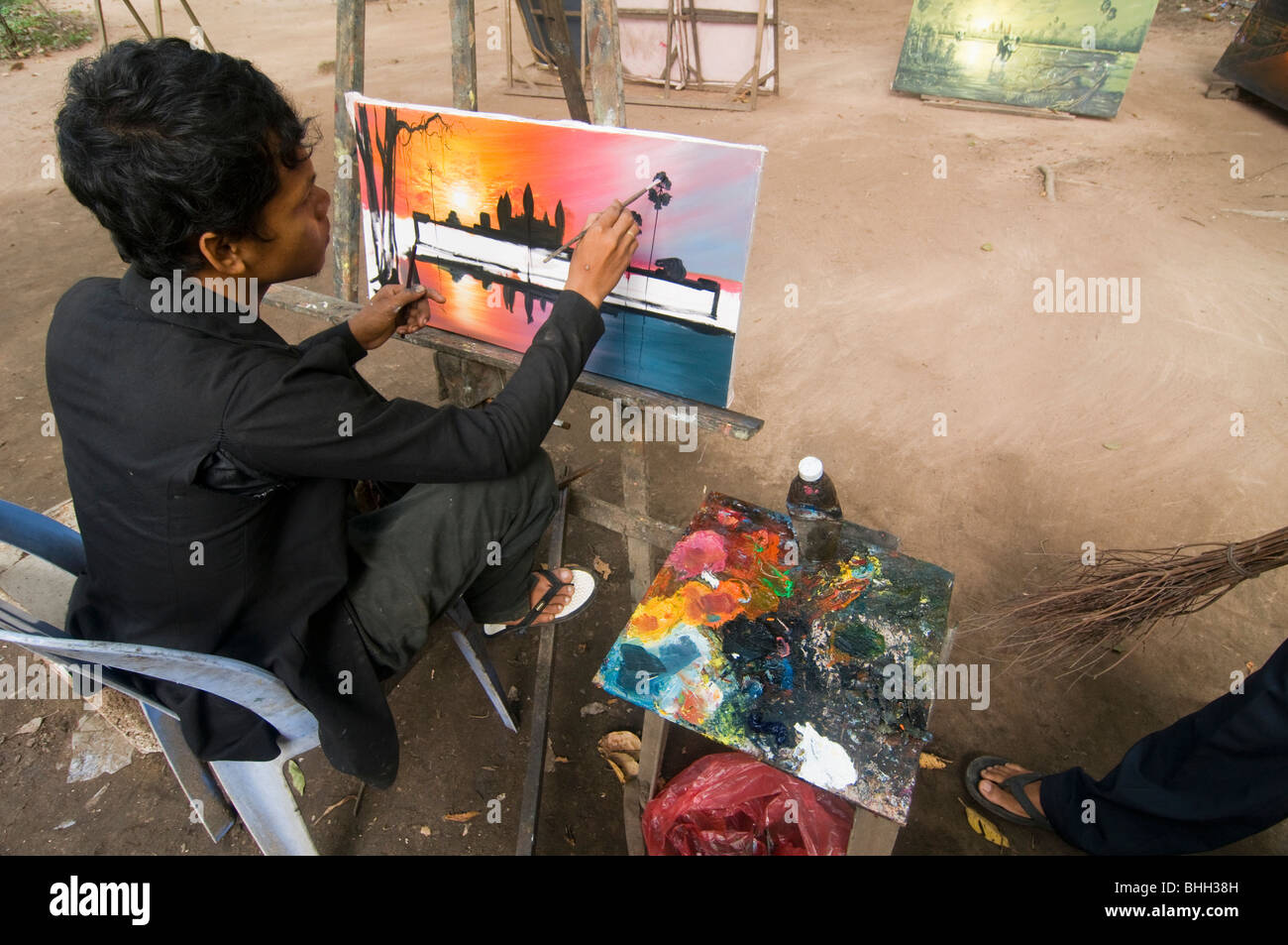 Artista al lavoro dipinto scene del tempio di Angkor Wat in Cambogia Foto Stock