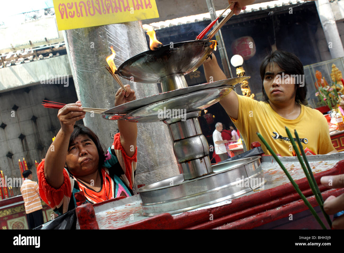 Persone che utilizzano olio per lampada nel tempio Cinese , Bangkok Chinatown , Capodanno cinese 2010 Foto Stock