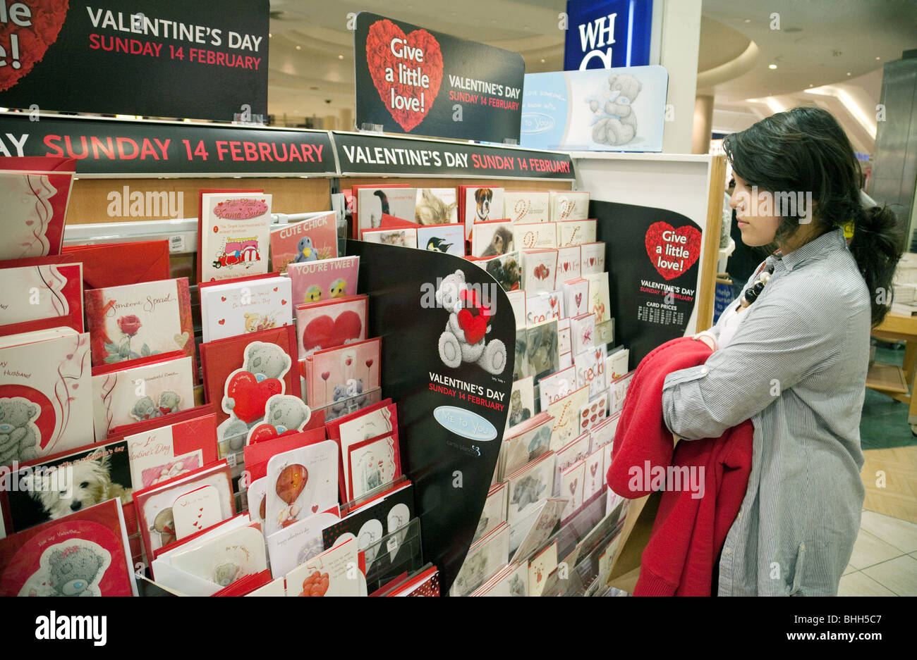 Ragazza adolescente acquisto di schede san valentino, W H Smiths, Bluewater Shopping Mall, Kent REGNO UNITO Foto Stock