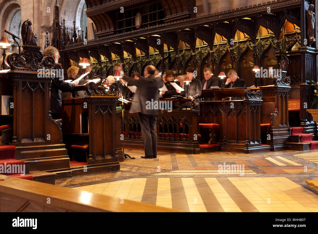 Bella voce e armonia al coro pratica all'interno il capiente Hereford Cathedral, Herefordshire, Inghilterra. Foto Stock