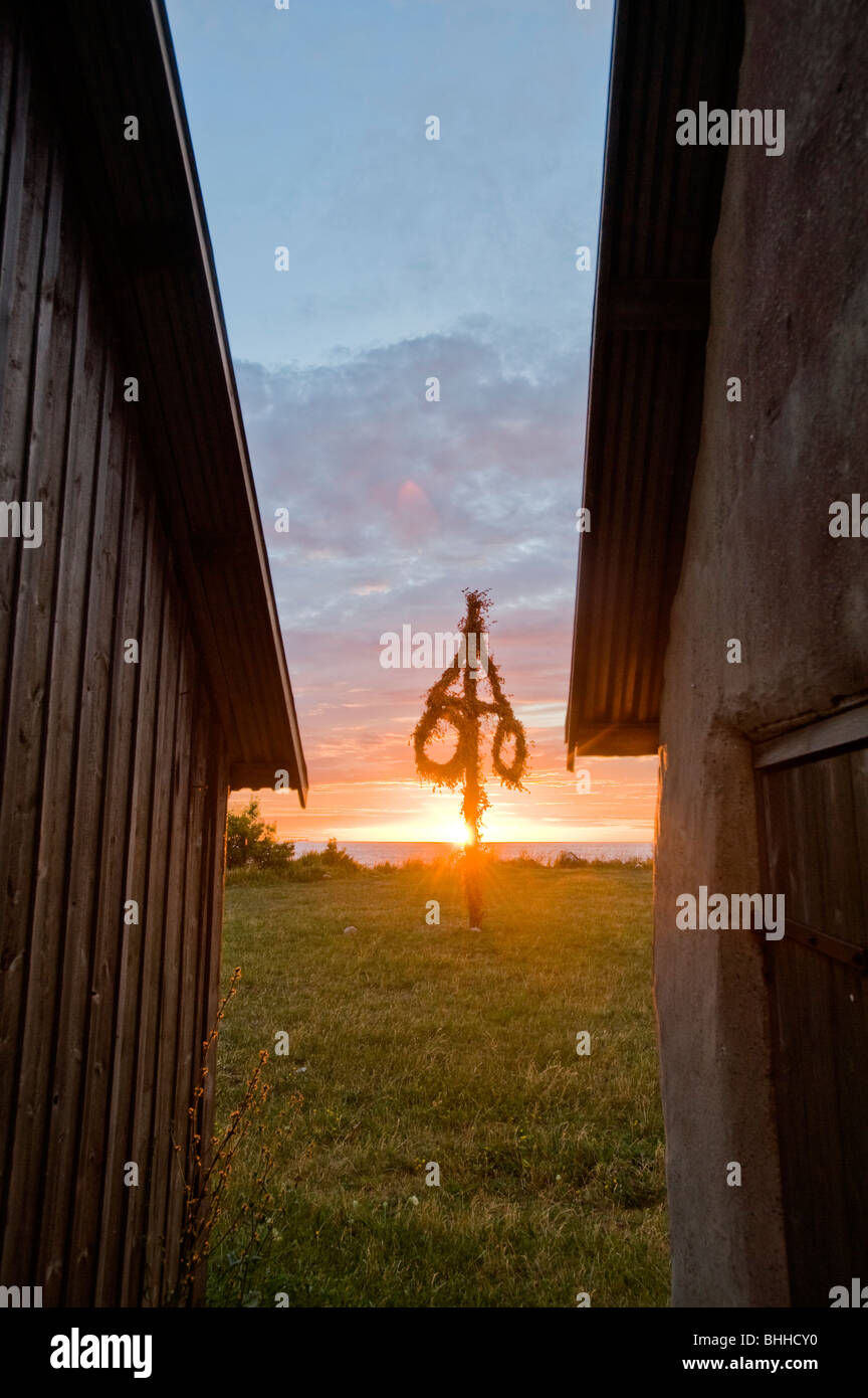 Un maypole tra due case, Svezia. Foto Stock