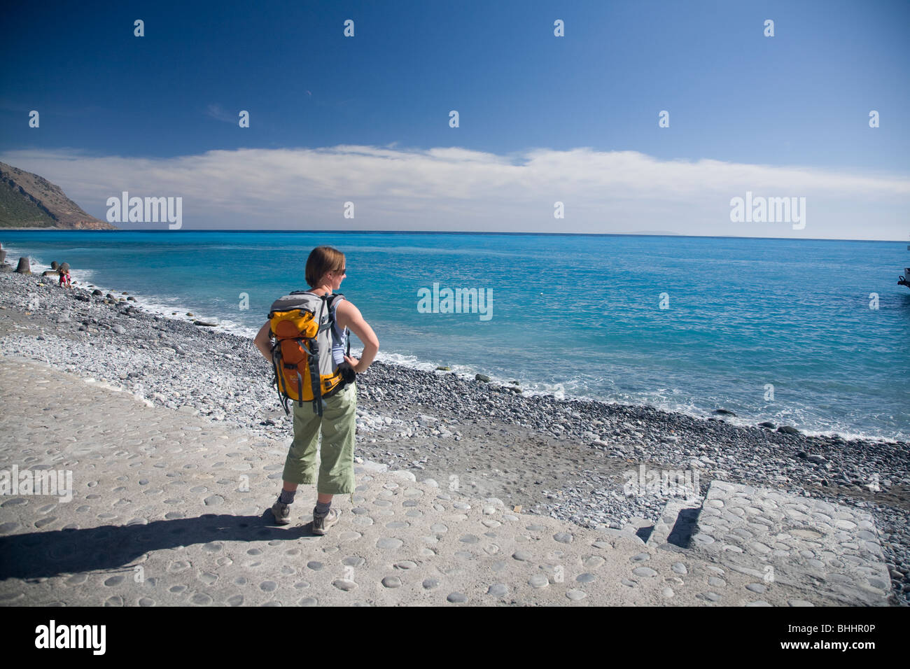 Escursionista presso il lungomare di Agia Roumeli, alla base della gola di Samaria, Creta, Grecia. Foto Stock