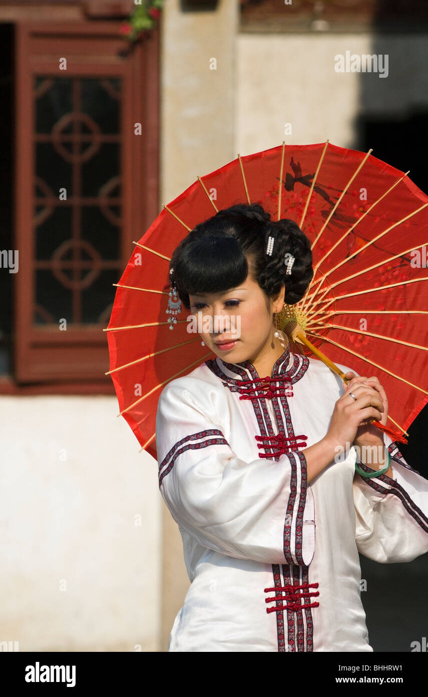 Donna con un ombrello rosso nell'acqua storica area di città di Suzhou, provincia dello Jiangsu, Cina e Asia Foto Stock