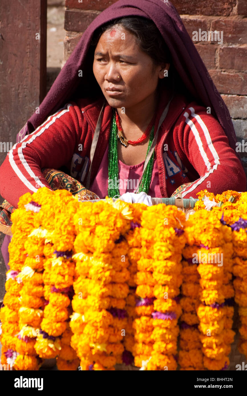 Il nepalese donna vendita di ghirlande di fiori nel centro de Kathmandu, Nepal Foto Stock