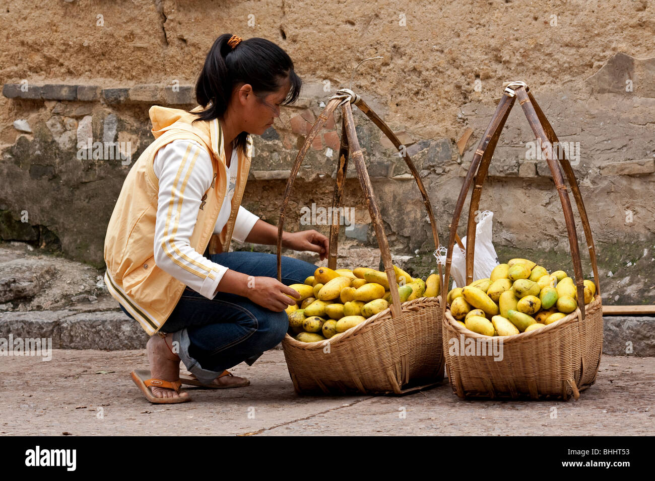 Ragazza cinese di vendita di manghi al mercato Jianshui in Yunnan, Cina Foto Stock