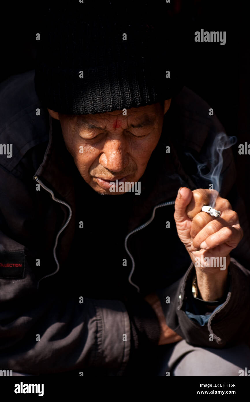 Il nepalese di prendere una pausa sigaretta nella trafficata Kathmandu, Nepal Foto Stock