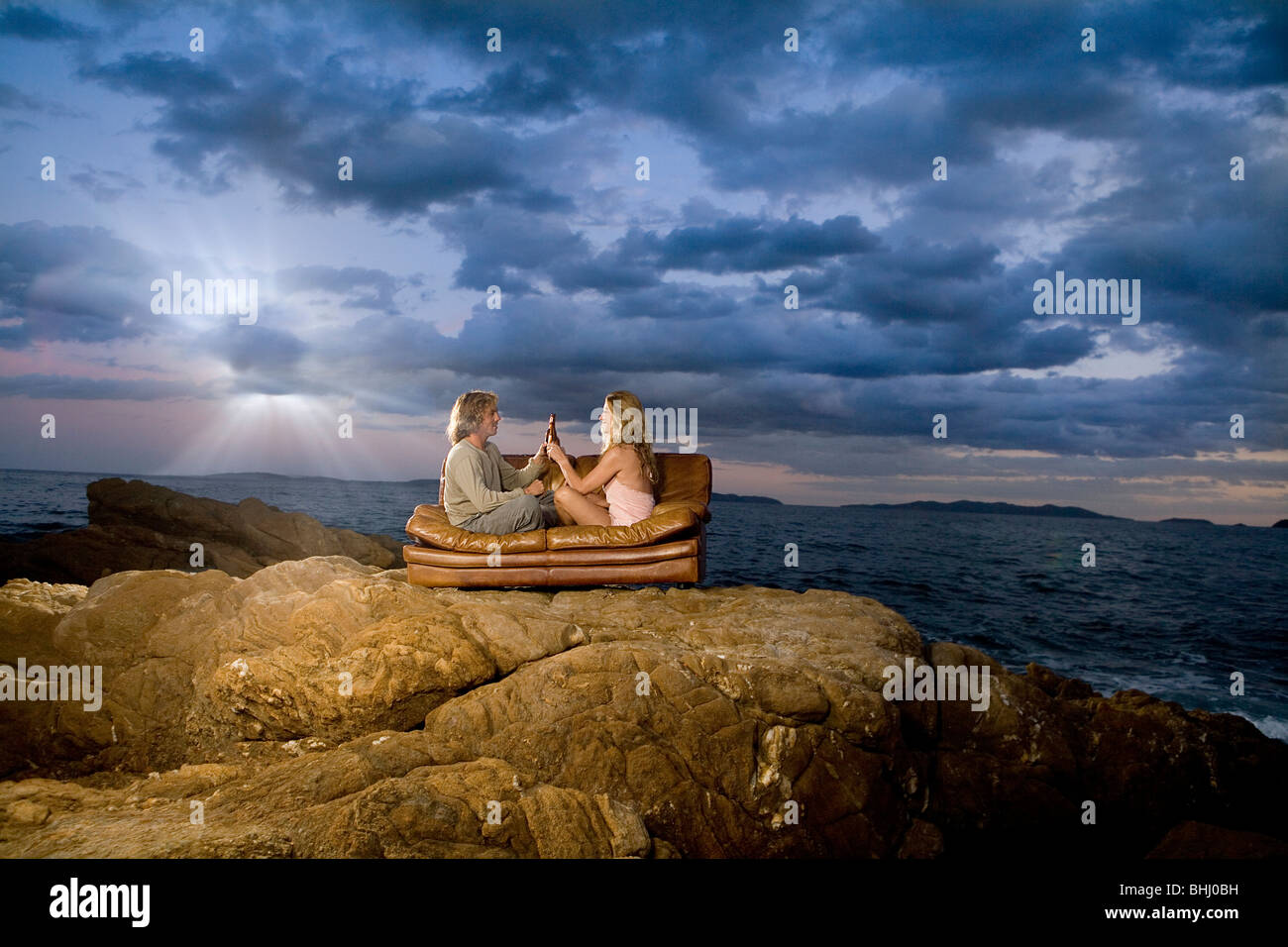 Giovane toast birra sul lettino al mare Foto Stock