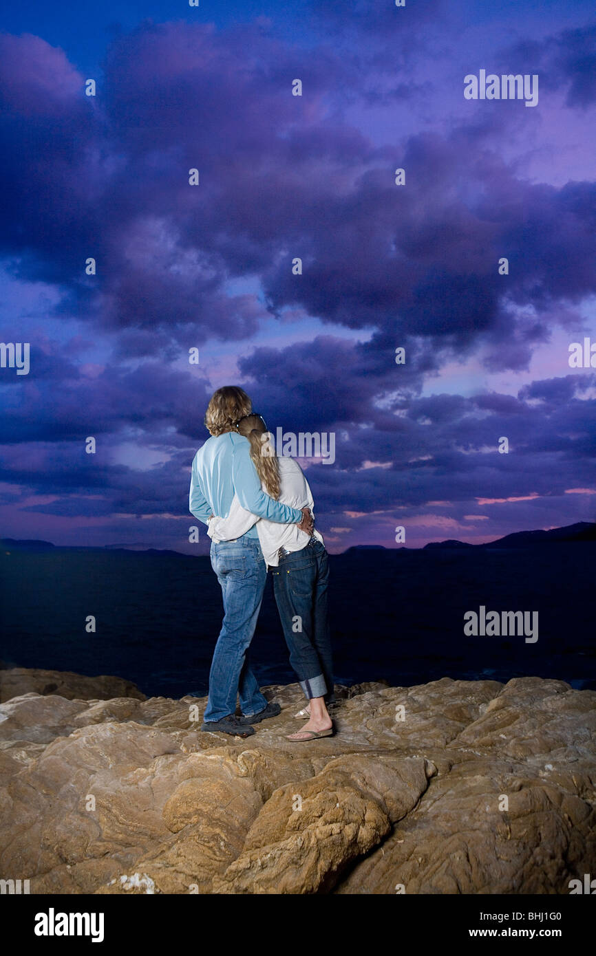 Giovane guardare sky su roccia Foto Stock