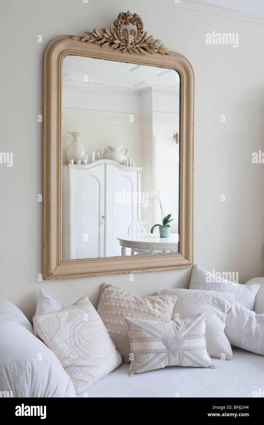 Specchio incorniciato al di sopra di dormeuse con cuscini Foto Stock