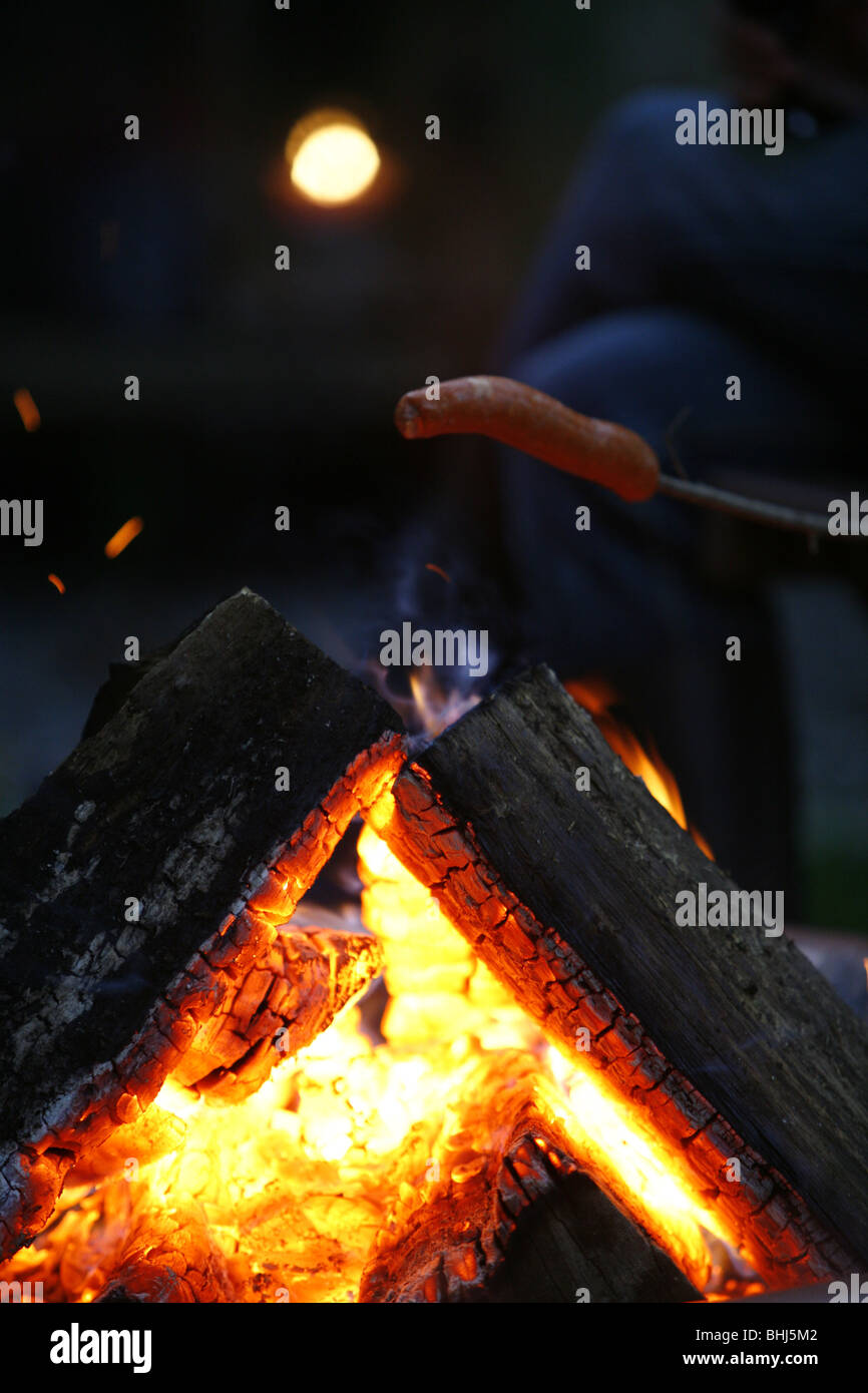 Una salsiccia di essere cucinato a fuoco Foto Stock