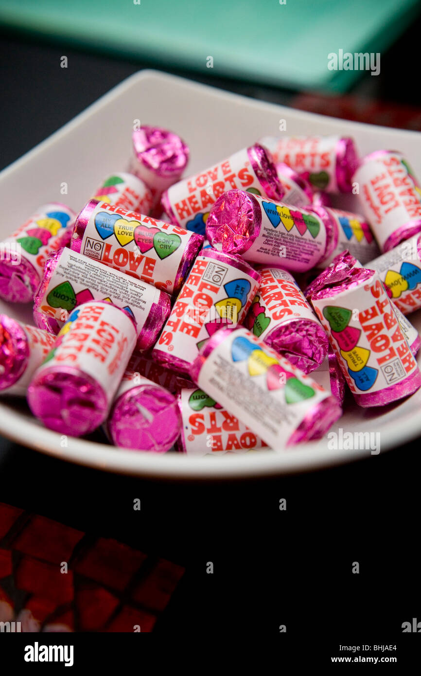 Un piatto di avvolto amore cuore caramelle in mini pacchetti di tubo Foto Stock