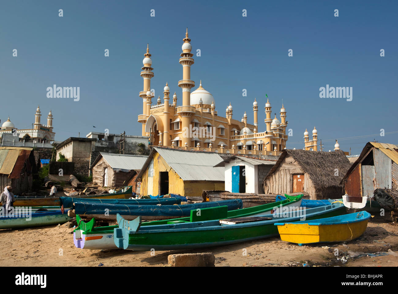 India Kerala, Kovalam, villaggio Vizhinjam coloratissime barche di pescatori sulla spiaggia di fronte della moschea Foto Stock