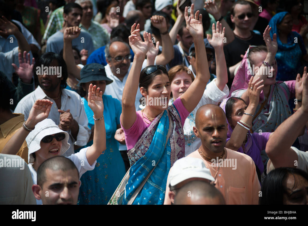 Carro Rathayatra festival, Londra. I devoti alzare le mani in aria in processione Foto Stock