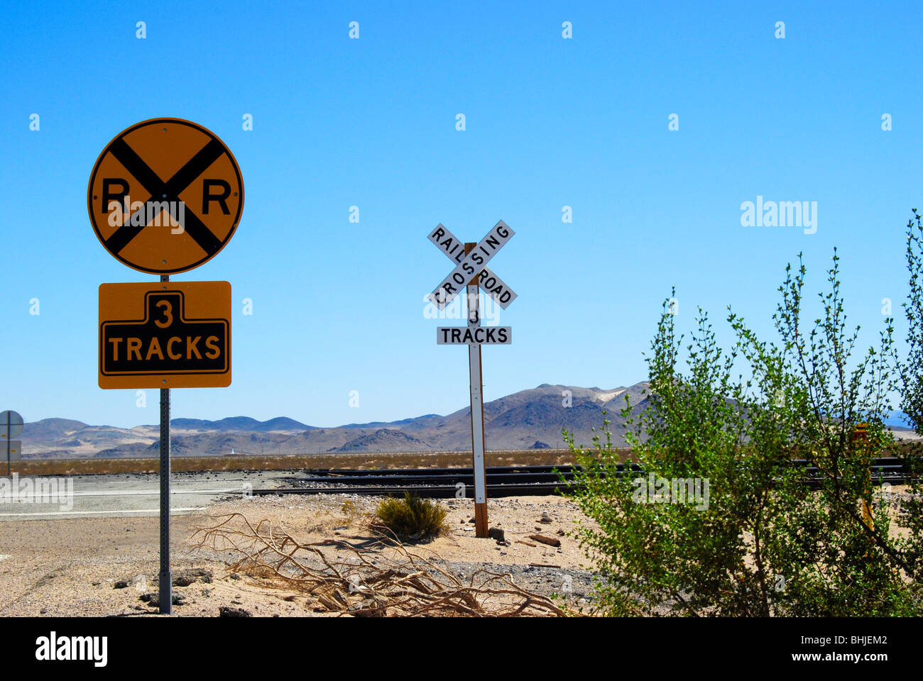 Attraversamento ferroviario segni contro il luminoso cielo blu Foto Stock