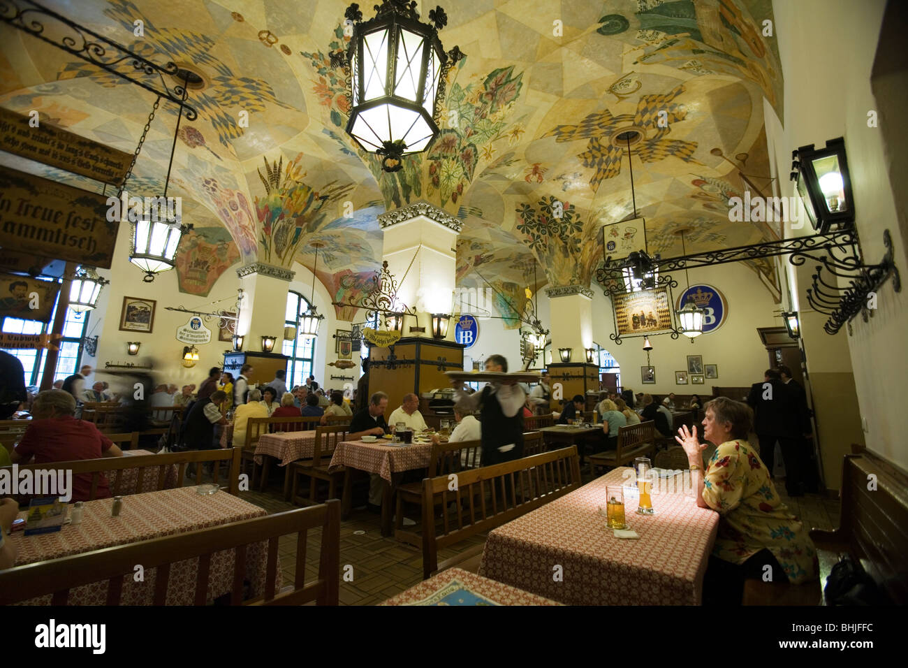 Una donna alla sua tavola guardando l'elaborato soffitto a la Hofbrauhaus am Platzl. Monaco di Baviera, Germania Foto Stock