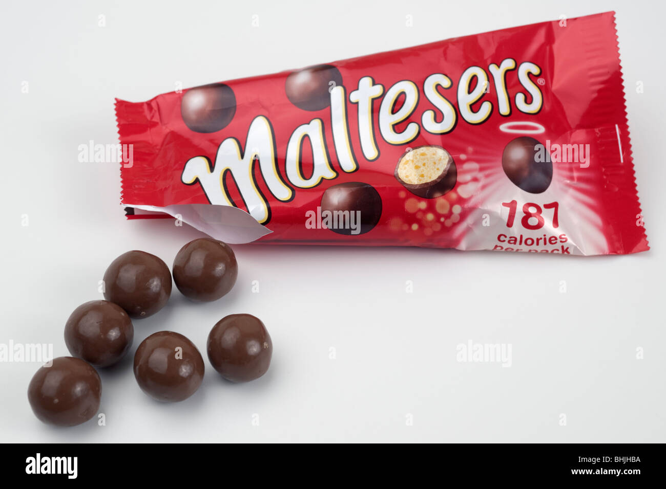 Aprire il sacchetto di Maltesers spargimento su una superficie bianca Foto Stock