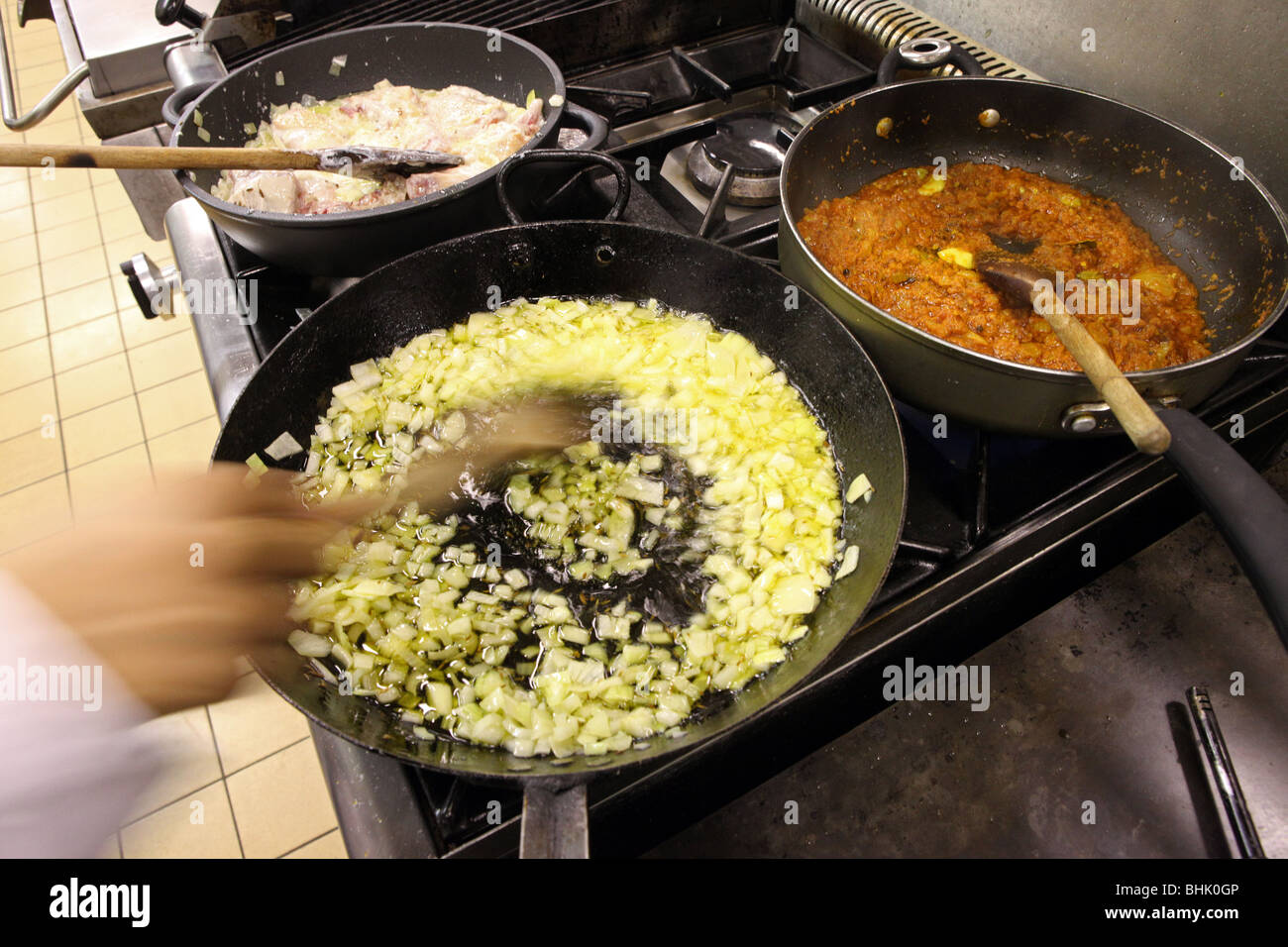 Curry viene cucinato in una padella sulla parte superiore di un forno in un ristorante nel Regno Unito Foto Stock