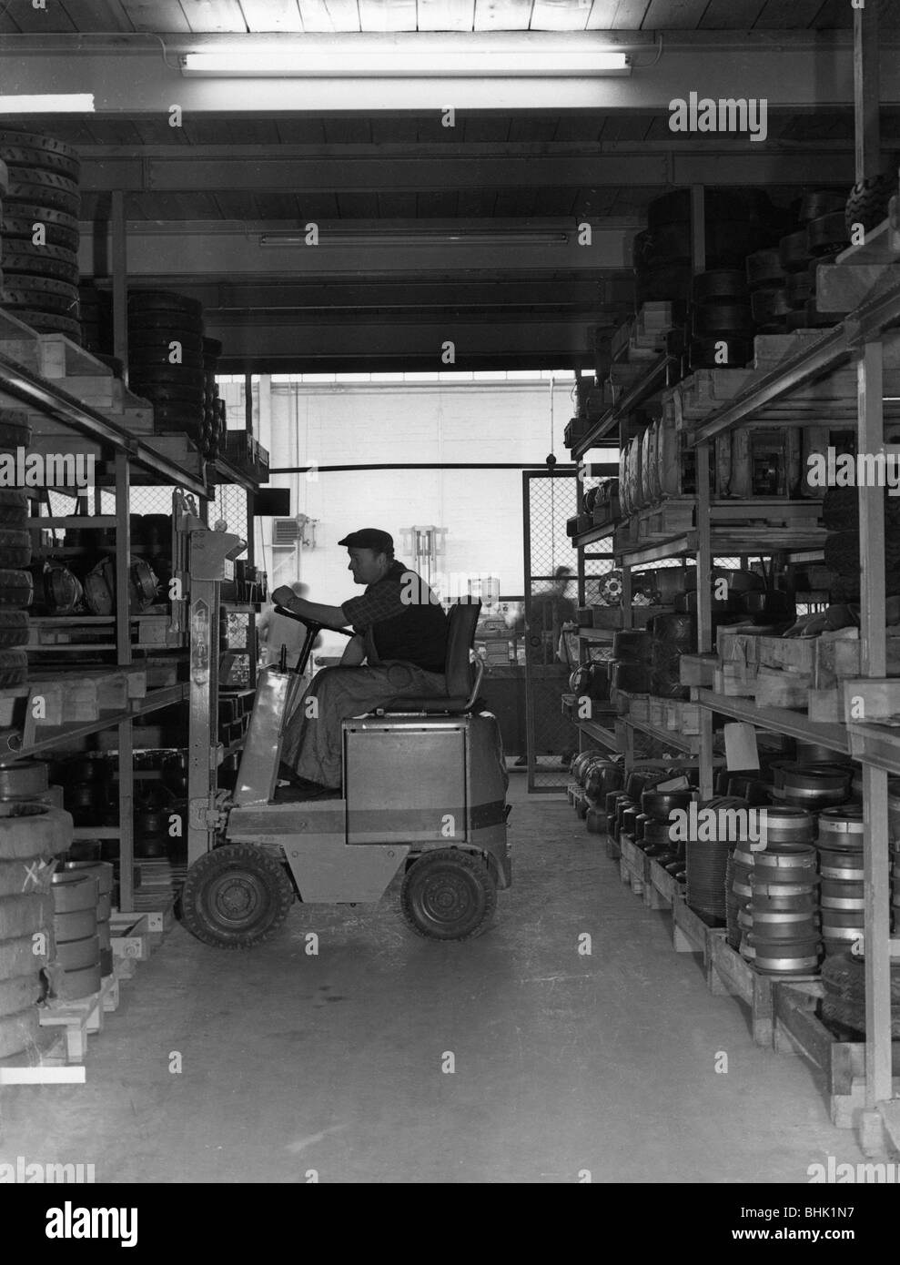 Persone, professioni, supervisore del negozio, durante il suo lavoro in deposito di pneumatici, con carrello elevatore a forche, Germania, 1960s, , Foto Stock