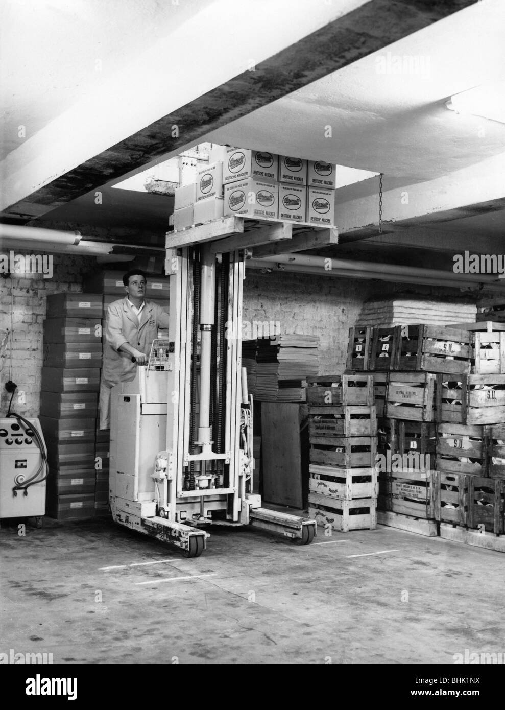 Persone, professioni, supervisore del negozio, durante il suo lavoro in deposito di pneumatici, con carrello elevatore a forche, Germania, 1960s, , Foto Stock