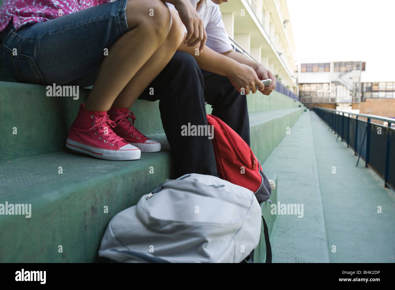 Gli adolescenti seduti insieme su fasi, sezione bassa Foto Stock