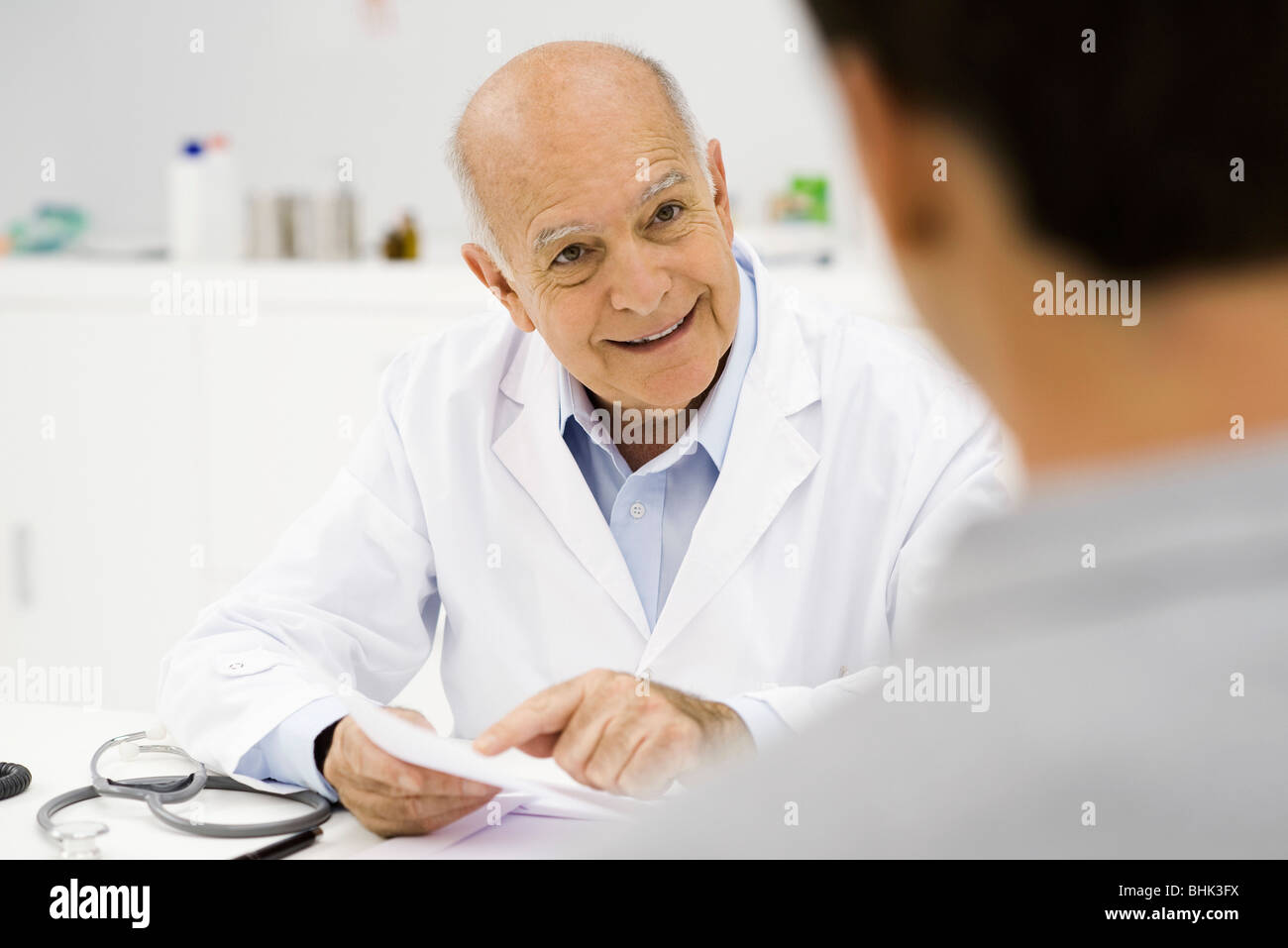 Medico allegramente per spiegare i risultati positivi per il paziente Foto Stock