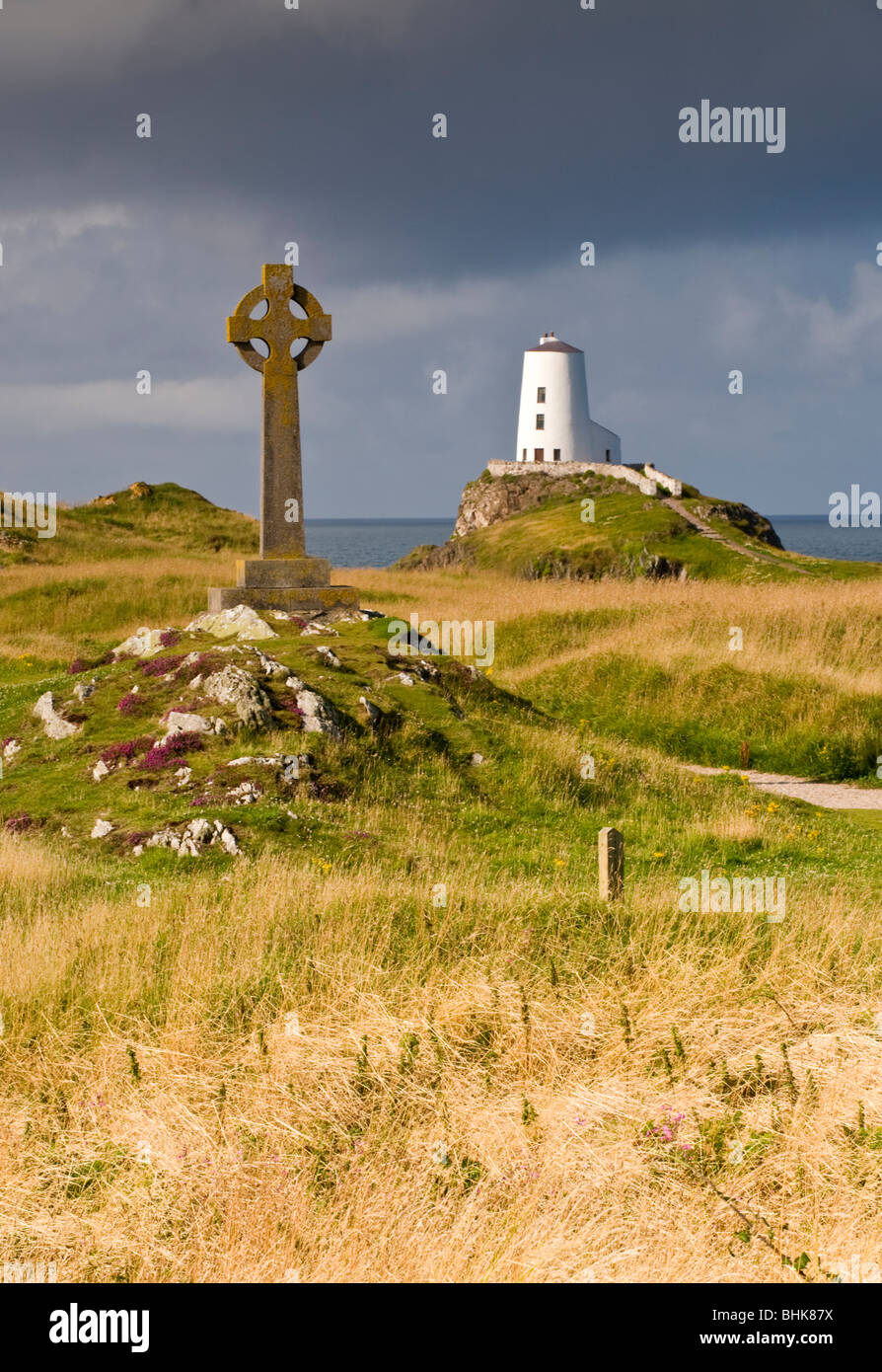 Croce di pietra e faro sull isola di Llanddwyn Riserva Naturale Nazionale, vicino Newborough, Anglesey, Galles del Nord, Regno Unito Foto Stock