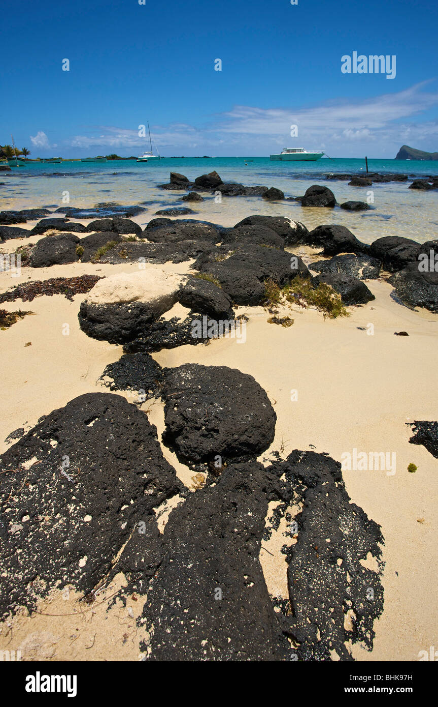 Sabbia e rocce in corrispondenza del bordo del mare dell'Isola di Mauritius. Foto Stock