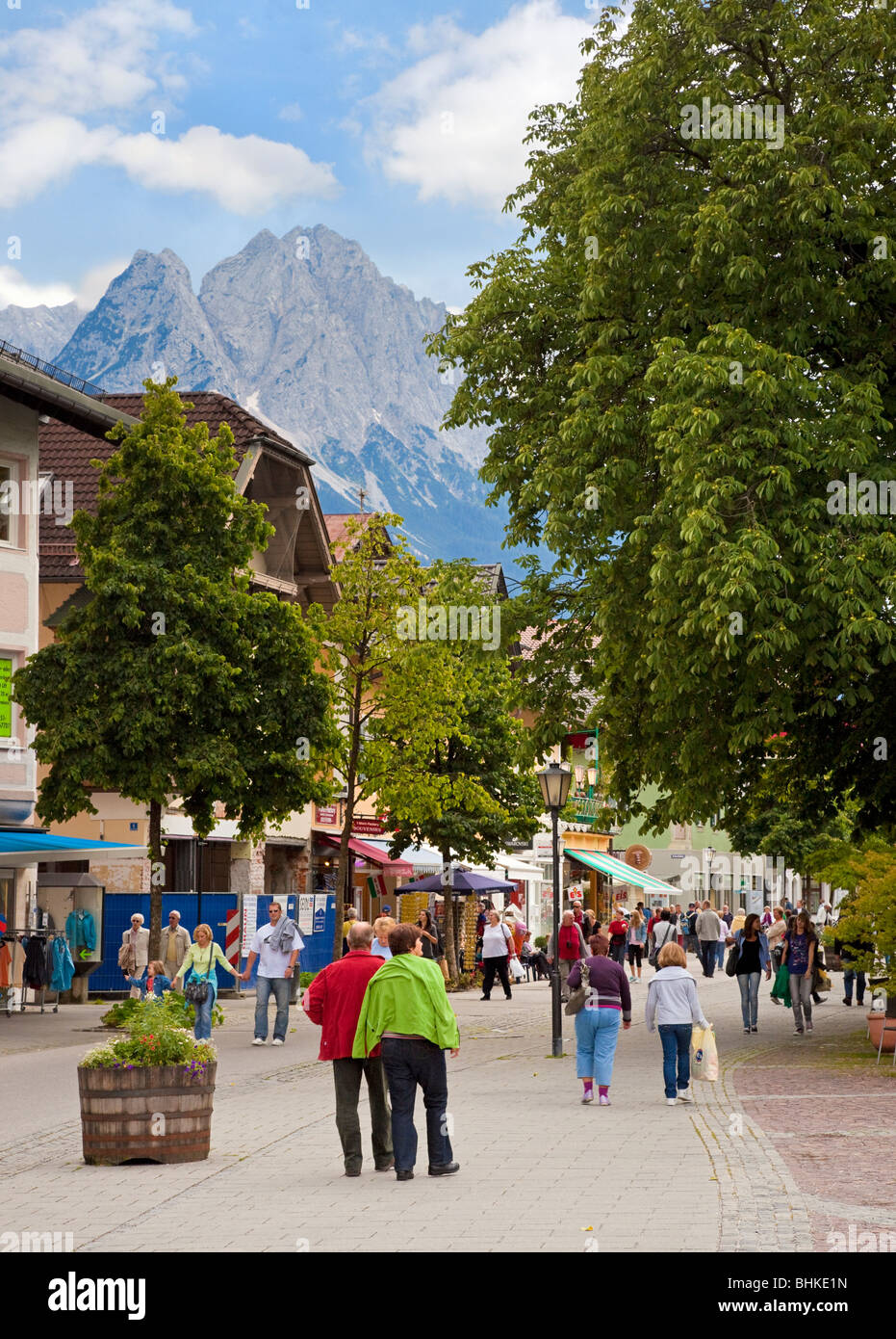 Garmisch-Partenkirchen, Germania - gente e negozi nella via principale del centro di Garmisch, Baviera, con il monte Zugspitze sullo sfondo Foto Stock
