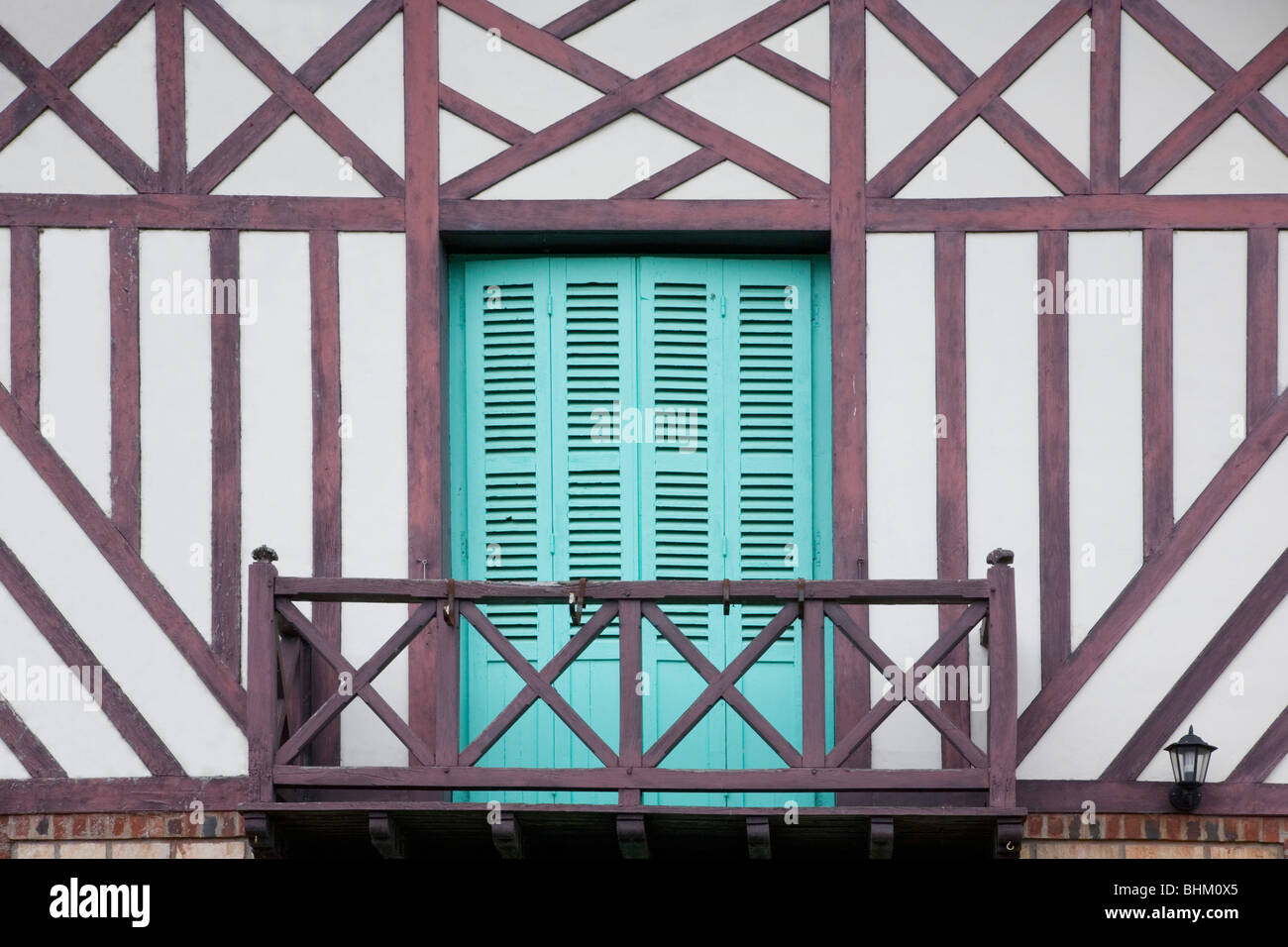 Beuvron-en-Auge, Normandia, Francia. Persiane color turchese e balcone di legno di mezzo in legno casa in paese. Foto Stock