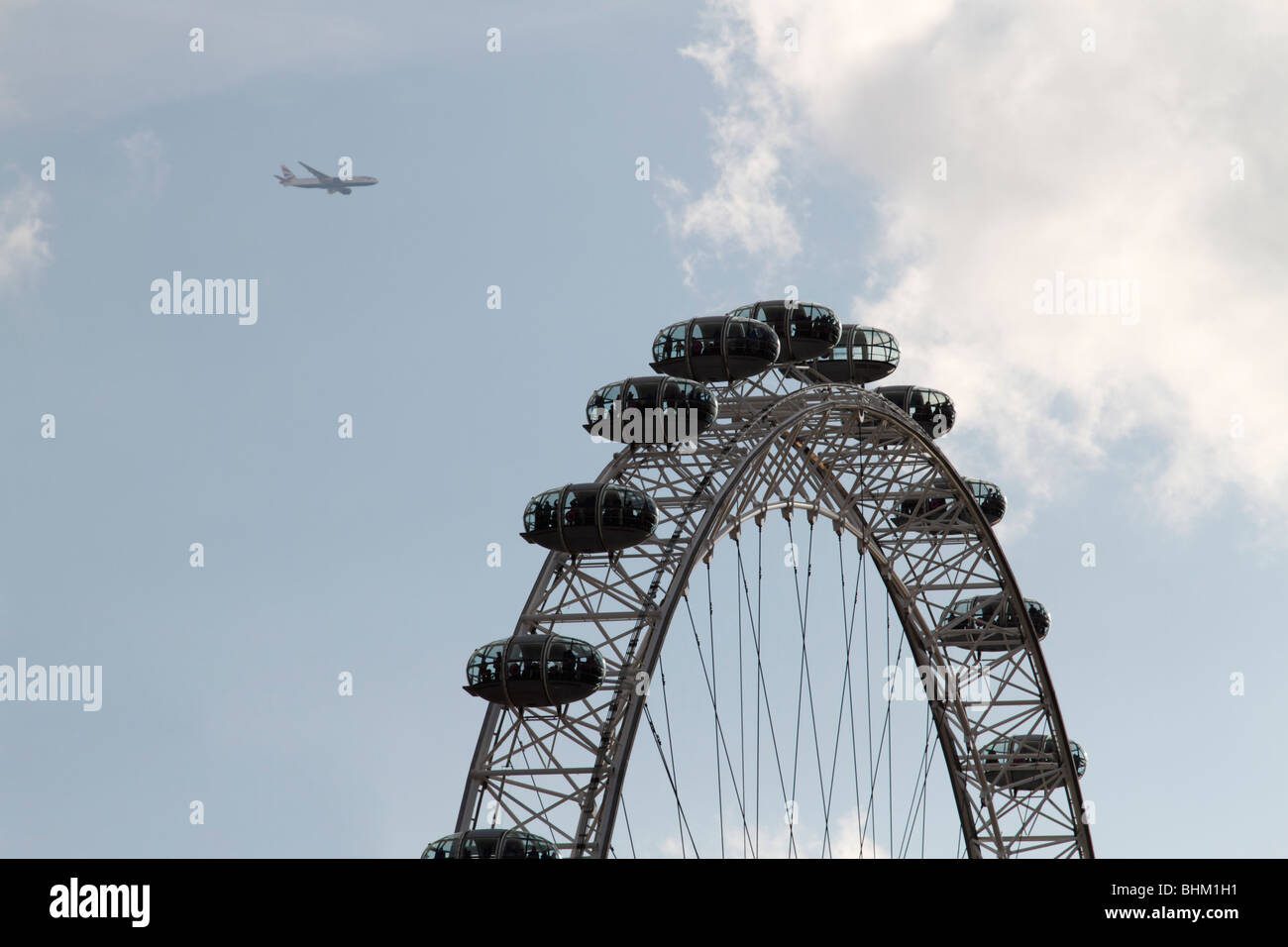 Vista del London Eye sulla sponda sud del Tamigi con un British Airways piano volare al di sopra di esso, Londra Foto Stock