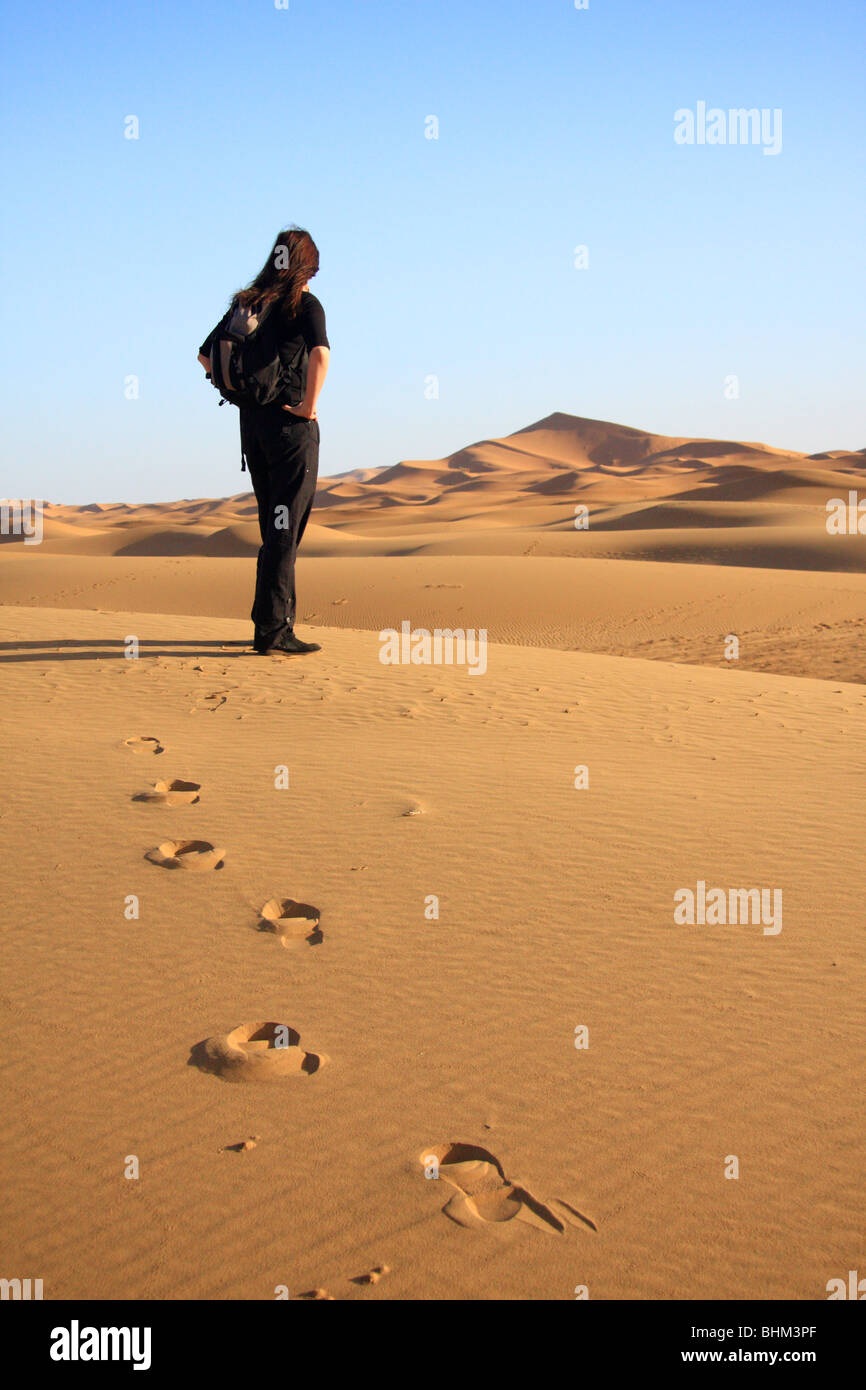 Turista femminile si affaccia su Erg Chebbi dune di sabbia nel deserto del Sahara vicino a Merzouga, Marocco, Africa del Nord Foto Stock